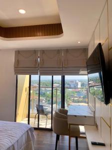 1 dormitorio con cama, escritorio y vistas en Apartemen Patraland Amarta, en Kejayan