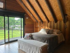 法罗皮利亚Vale do Vento Inn的一间卧室，里面有一张床和一扇大窗户。