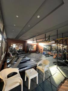 a room with chairs and a gym with treadmills at alamari gardens in Irbid