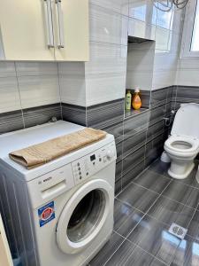 a washing machine in a bathroom with a toilet at Apartment for rent Piqeras, Sarande in Piqeras