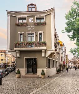 a building on a street with flowers on it at Boutique Guest House Coco in Plovdiv