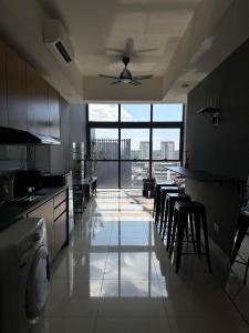 a kitchen with tables and chairs and a large window at 3volution Stays in Petaling Jaya