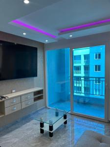 a living room with a large tv and a large window at Apartamento Lujoso Yumbo in Arroyo Hondo