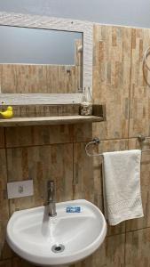 a bathroom sink with a mirror and a towel at Pousada Dona Elena in Penha +72 photos