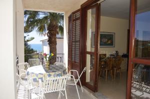una mesa y sillas en un balcón con una palmera en Villa Vella, en Sciacca