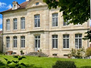 a large stone building with stairs and grass at Hôtel Particulier, Maison Jazey. in Semur-en-Auxois