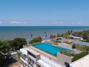 an aerial view of a building with a swimming pool and the ocean at The Blu X Ocean view Family top floor in Ban Bang Saen (1)