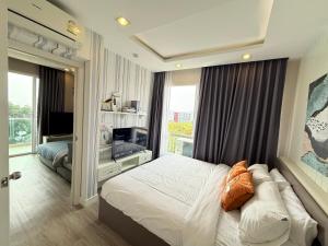 a bedroom with a bed and a television in it at The Blu X Ocean view Family top floor in Ban Bang Saen (1)