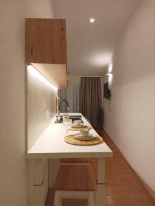 una cucina con piano di lavoro bianco e lavandino di Pluton a Primošten