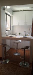 a kitchen with two bar stools and a sink at Bonito y cómodo ideal para trabajar in La Paz