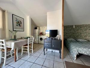a bedroom with a bed and a table and a desk with a television at Lok'a Life in Villenave-dʼOrnon