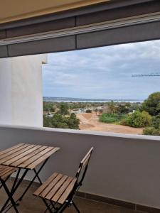 a window in a room with a wooden table and chairs at Mirada Ponent in Es Pujols