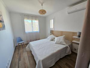 a bedroom with a white bed and a blue chair at Au Farniente in Vallauris