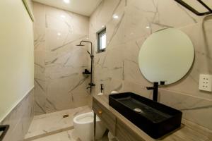 a bathroom with a black sink and a mirror at Homestay Cô Hai in Xóm Rạch Già