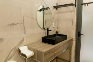 a bathroom with a black sink and a mirror at Homestay Cô Hai in Xóm Rạch Già