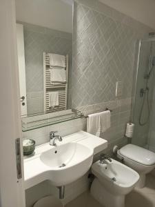 ポルト・サント・ステーファノにあるLuxury beach houseの洗面台、トイレ、鏡のあるバスルーム