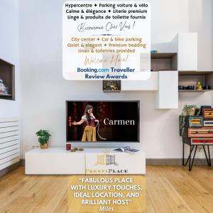 a living room with a tv and a wall with a poster at La Cour de l'Opera - PrestiPlace Collection in Tours