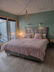 a bedroom with a large bed and a chandelier at summer house near Malmköping - Södermanland in Malmköping