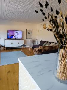 a living room with a couch and a vase of flowers at summer house near Malmköping - Södermanland in Malmköping