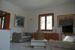 a living room with a couch and a tv at Casa Vacanze La Vite in Stintino