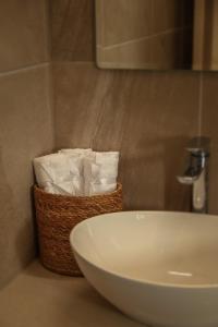 a basket of toilet paper sitting next to a sink at Vina Oliva Hotel in Pissouri +24 photos