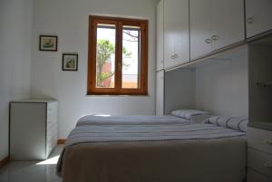 a bedroom with two beds and a window at Casa Vacanze La Vite in Stintino