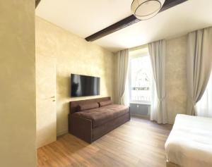 a bedroom with a couch and a flat screen tv at Pantheon Urbes Collection in Rome