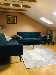 a living room with a blue couch and a table at Central apartment in Pristina