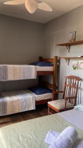 a bedroom with two bunk beds and a chair at Pousada Dona Elena in Penha