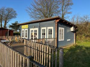 una casetta blu con una recinzione in legno di Two bedroom Holiday Home with countryside view a St Austell