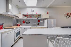 a kitchen with white cabinets and white appliances at Maison Papavero in La Teste-de-Buch