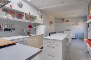 a kitchen with white counters and a white refrigerator at Maison Papavero in La Teste-de-Buch