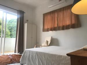 AmpitiyaにあるKandy Brick Bungalowのベッドと窓のある寝室