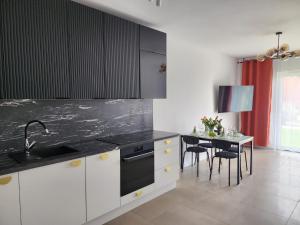 a kitchen with a sink and a table with chairs at Apartament Zielony Taras in Zgorzelec