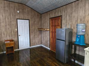 an empty kitchen with a refrigerator and a door at Hibiscus Cabin with AC at Freshwater Creek Cabanas in Hopkins