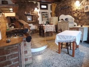 a kitchen with a stove and a table in a room at La taverna del gufo bed & breakfast in Sarule