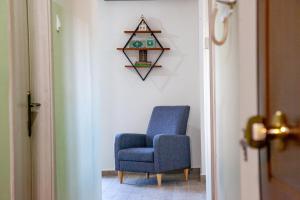 a blue chair sitting in a hallway next to a wall at Swans Luxury Apt in Kastoria