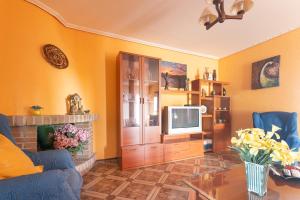 un salon avec des murs jaunes et une télévision dans l'établissement El estanque, à Galizano