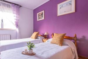 deux lits dans une chambre aux murs violets dans l'établissement El estanque, à Galizano