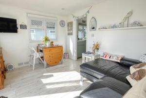 a living room with a couch and a table at The Happy Hedgehog in Mundesley