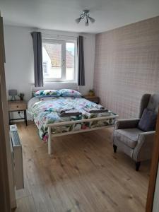 a bedroom with a bed and a chair and a window at A view to Caol, Fort William in Fort William