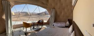 a room with a large window and a table and chairs at Rum Aranda camp & Jeep Tour in Wadi Rum
