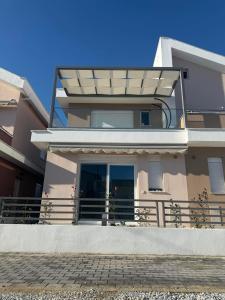 a house with a balcony with a glass door at Aegean dream house in Ofrínion