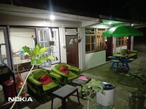a living room with a green couch and an umbrella at Yellow Bamboo Homestay in Mangpu