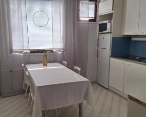 a kitchen with a table with a white table cloth on it at Miilunhovi kolmio in Petäjävesi
