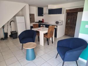a living room with a table and chairs and a kitchen at L'apaisant in Rodez