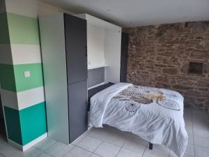 a bedroom with a bed and a brick wall at L'apaisant in Rodez
