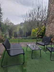 a group of chairs and a table on grass at L'apaisant in Rodez