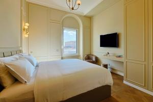 a bedroom with a white bed and a window at Residenza Alferini - San Pietro in Rome