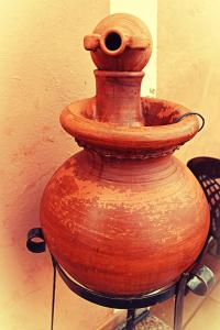 an old vase sitting on a stand next to a wall at O Refuxio de la Jerezana in Redondela